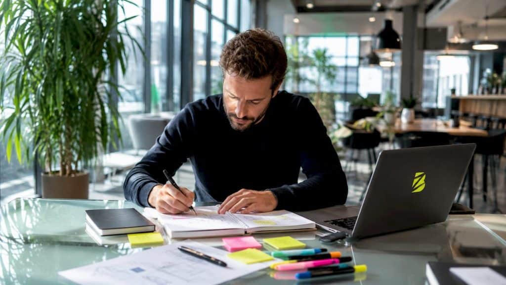 Un professionnel réfléchit à sa stratégie de génération de prospects dans son bureau.