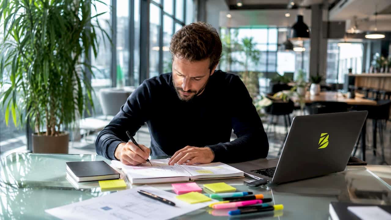 Un professionnel réfléchit à sa stratégie de génération de prospects dans son bureau.