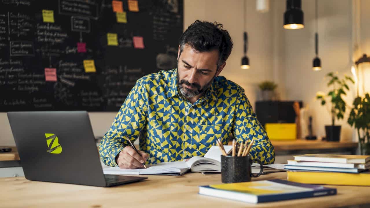 Un enseignant en classe, en train de concevoir des supports pédagogiques numériques pour ses élèves.