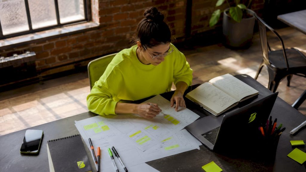 Un designer conçoit des maquettes UX dans un espace de coworking lumineux.