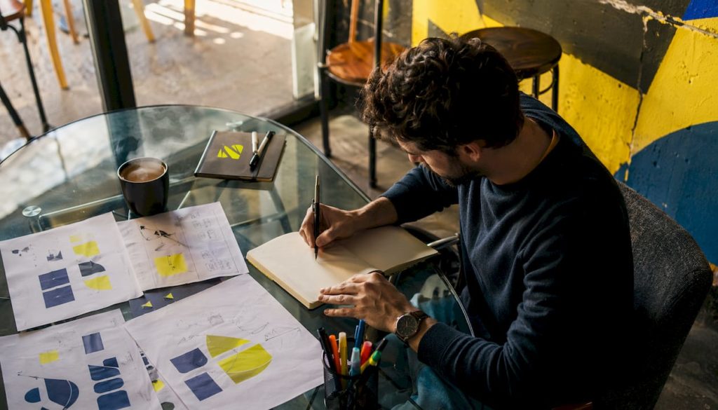 Une personne en pleine analyse de documents stratégiques liés à l’identité de marque, installée à son bureau.