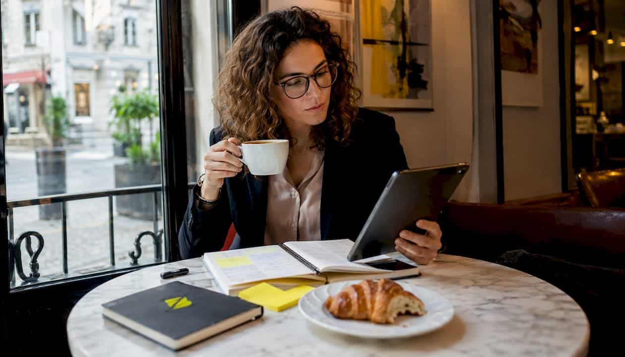 Une femme d'affaires examine différentes options de branding, installée à l'extérieur pour s'inspirer.
