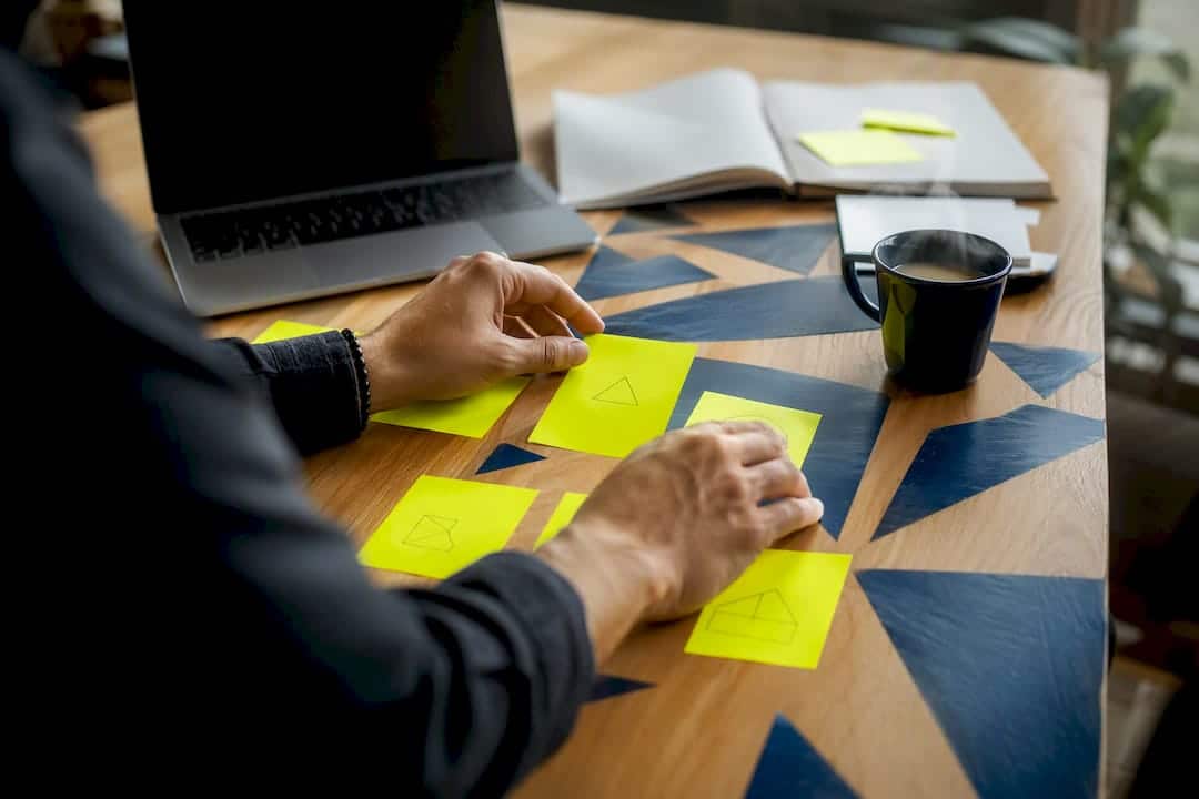 Des mains qui organisent des cartes de campagne marketing sur un bureau