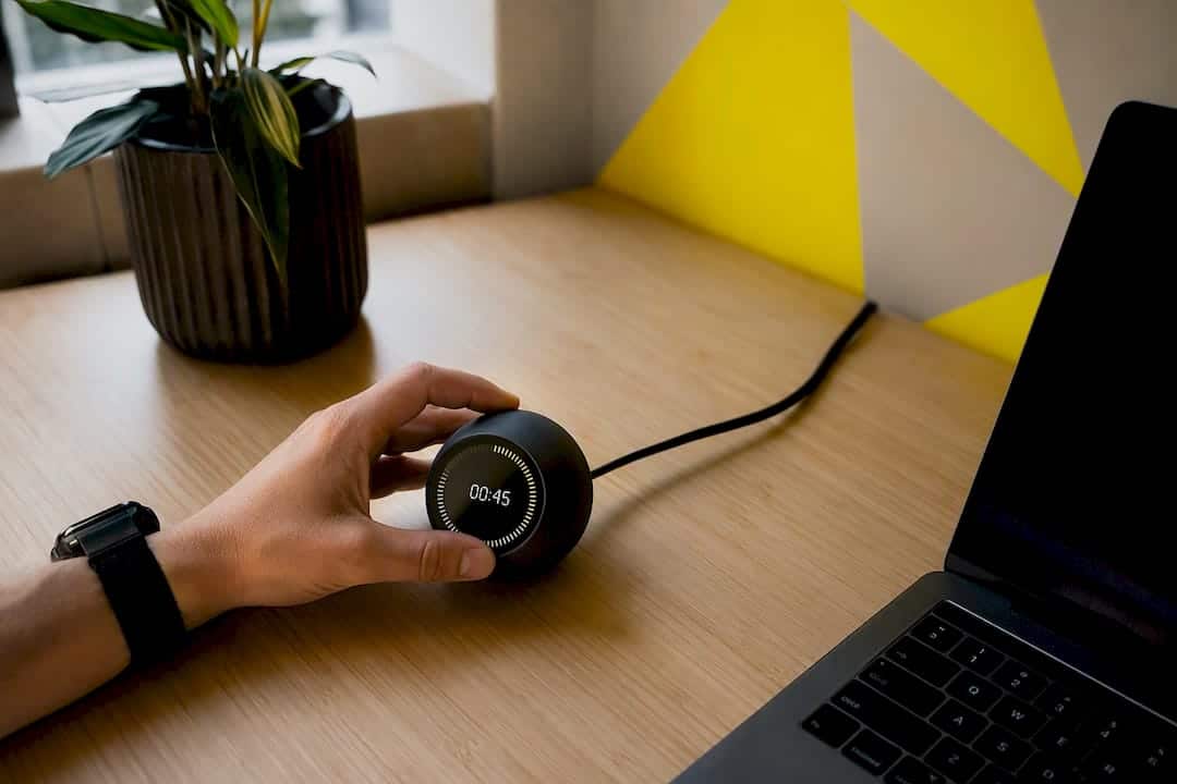 Main réglant un minuteur sur un bureau pour l'automatisation