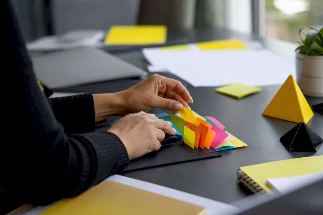 Mains organisant des onglets de planification sur un bureau marketing