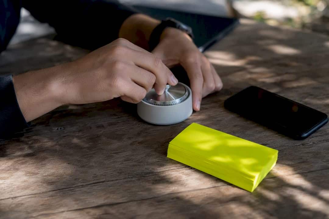 Mains réglant un minuteur sur un bureau marketing